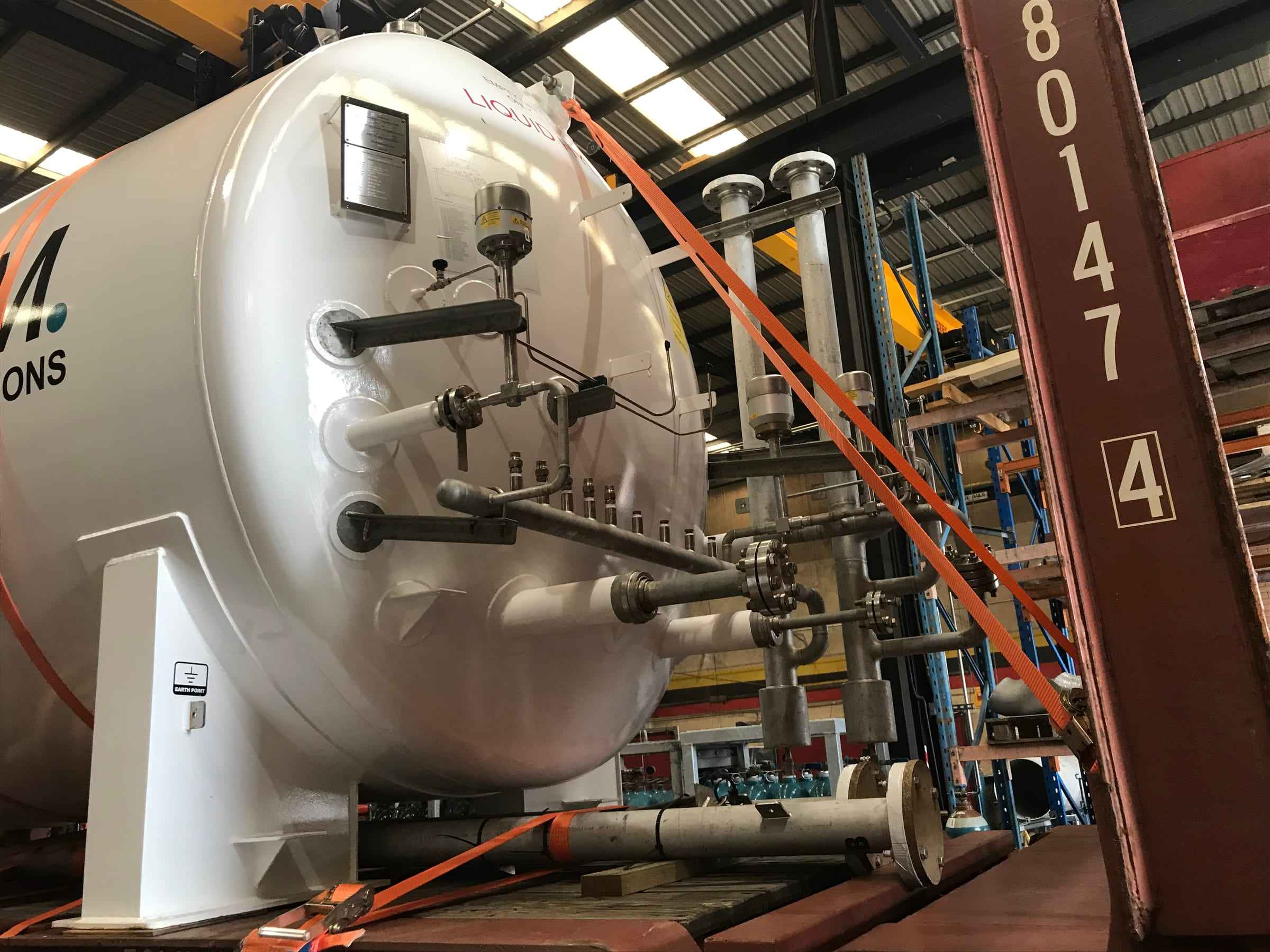 Liquid hydrogen storage tank with valves and pipework in a workshop