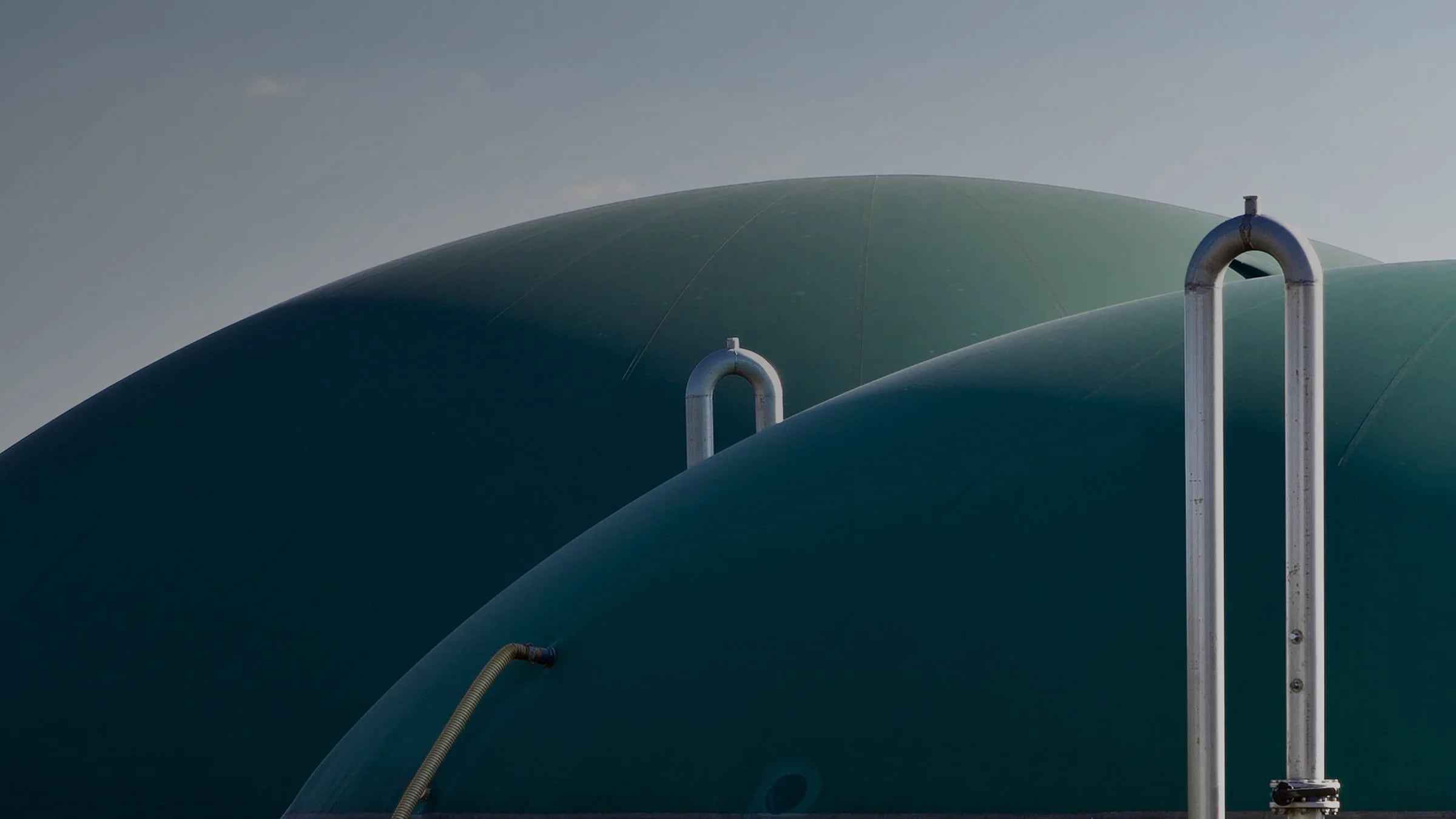Biogas storage domes against an evening sky