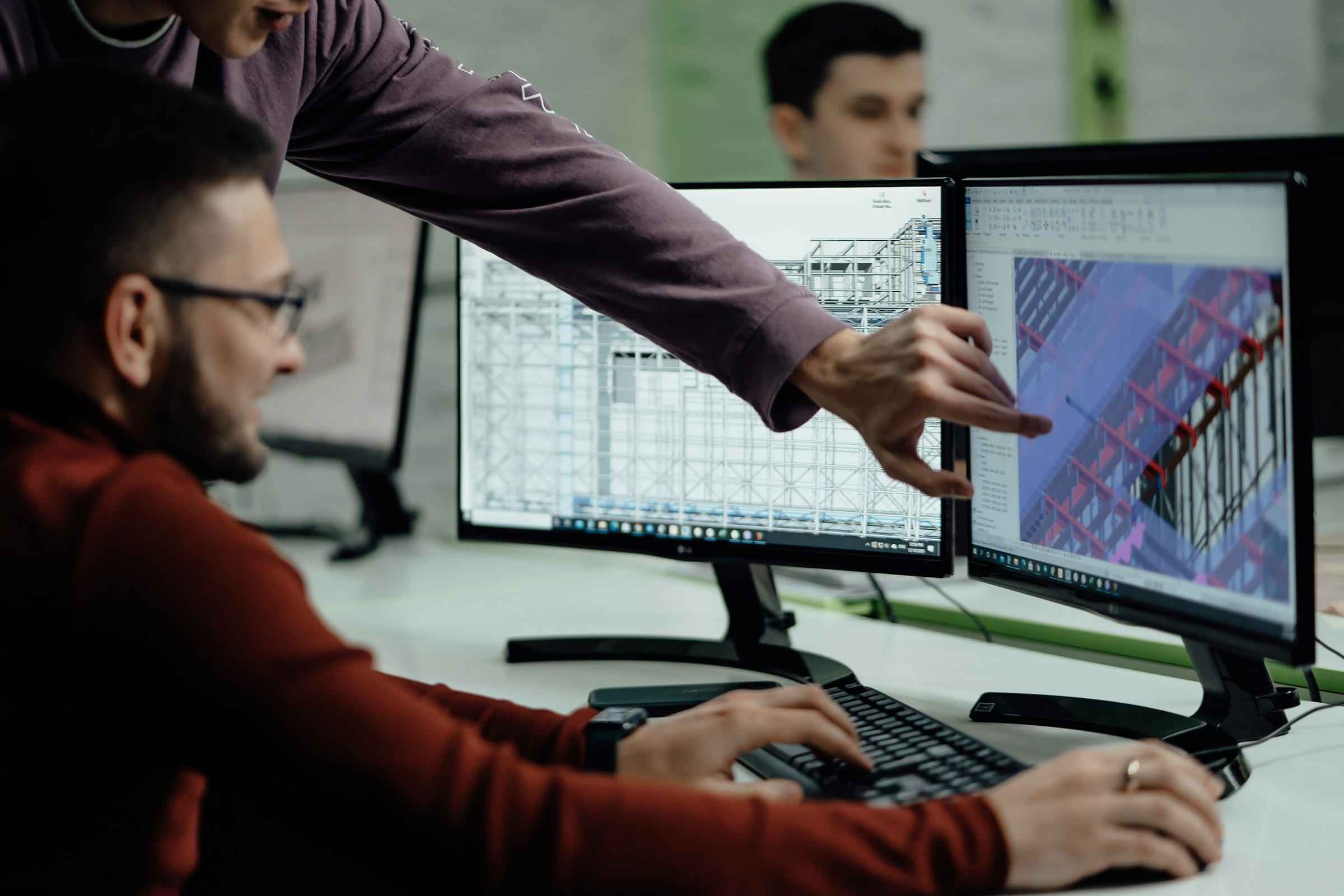 Engineers reviewing a 3D model on a computer screen