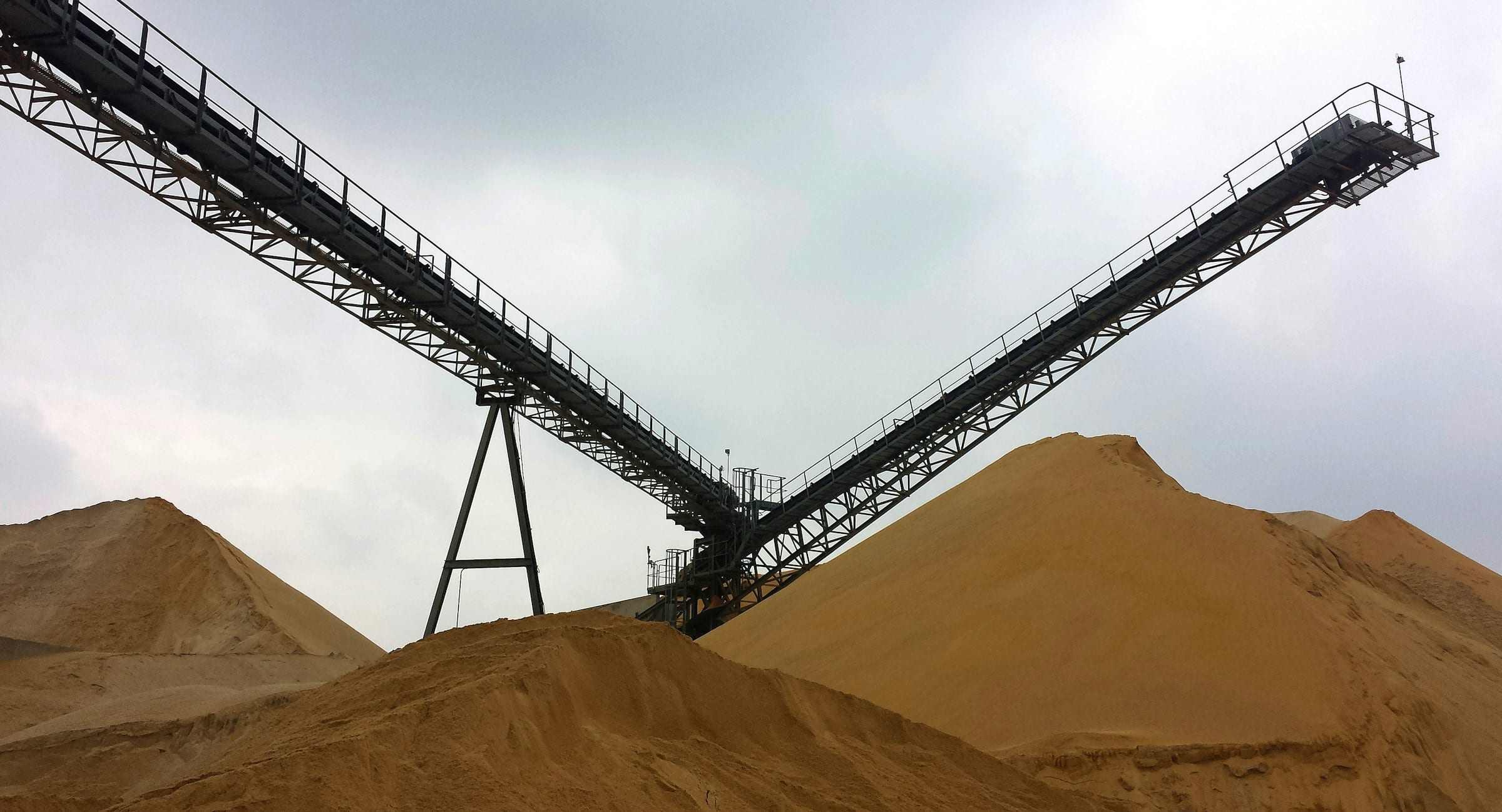 Conveyor stackers above mineral stockpiles
