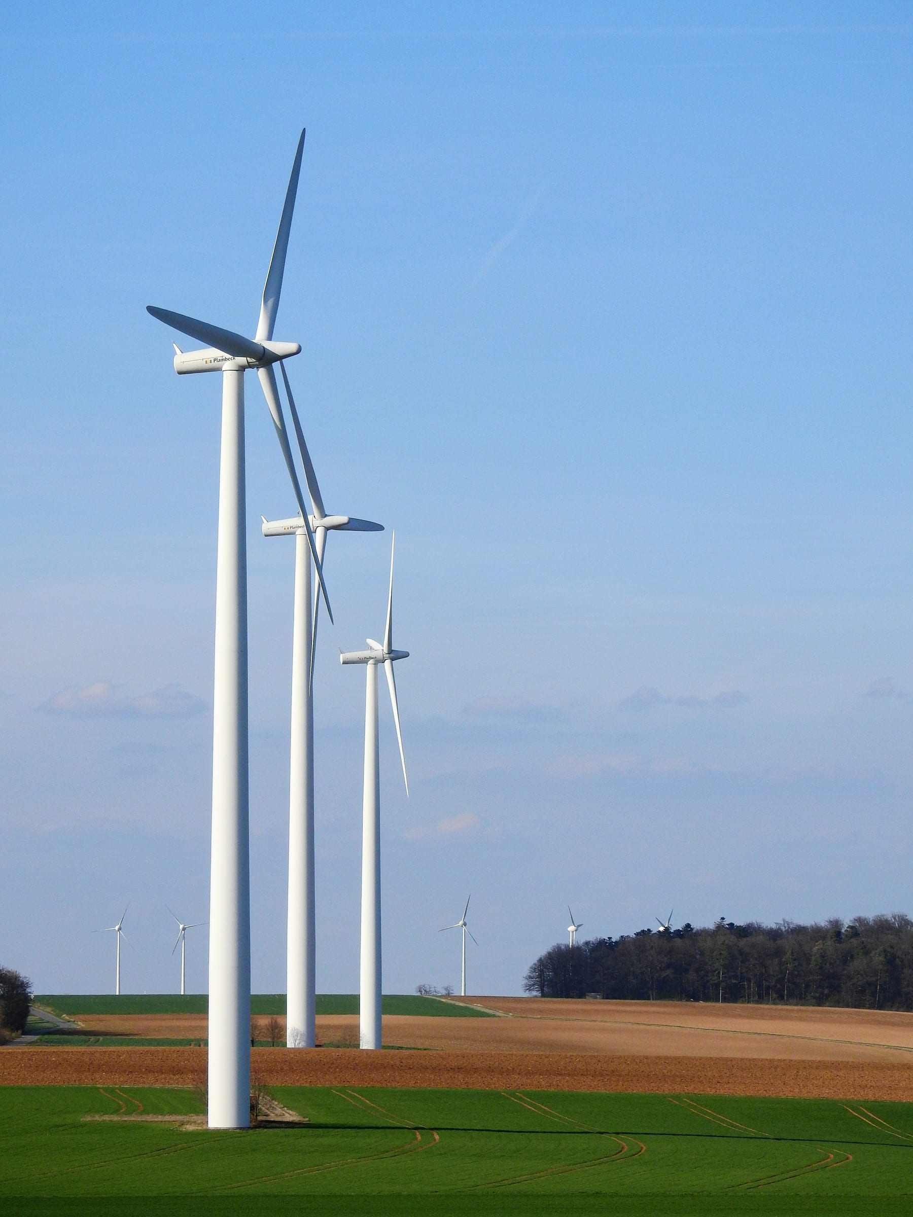 Wind turbines on farmland under a clear sky